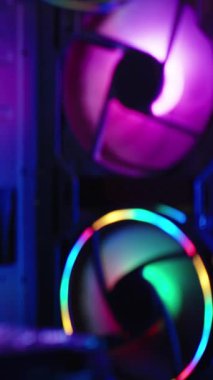 Dikey video. Teknolojik sıçrama ekranı arkaplanı için bulanık görüntü. Karanlıkta RGB ışıklandırması olan bir oyun bilgisayarının içindeki bileşenler.