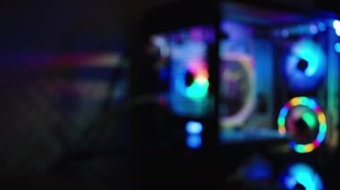 Teknoloji videoları için renkli arkaplan, karanlıkta gökkuşağı renkleriyle parıldayan bulanık efektli bir oyun bilgisayarı.