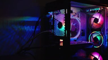 Gökkuşağı ışıklandırmalı bilgisayar oyunu davası. RGB ışığı karanlıkta duvara yansıtılır..