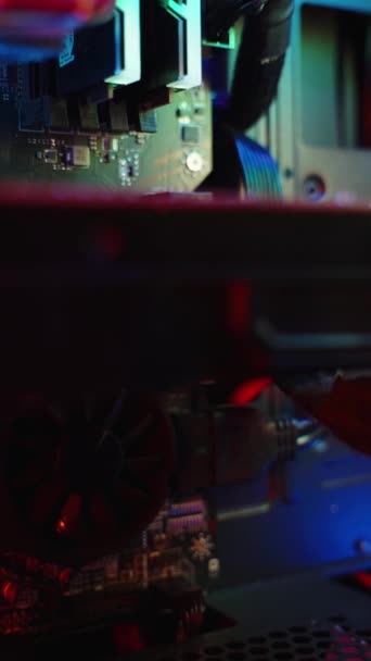 バーティカルビデオ 暗闇の中で輝くゲームPcの電子コンポーネントに虹のバックライト スライダー — ストック動画