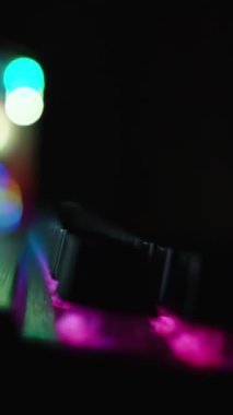 Dikey video. Karanlık oda, renkli ışıklandırmalı oyun bilgisayarı. Kamera, klavyeden PC üzerindeki mesafeye kayar.