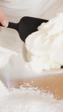 Pasta şefi krema hazırlar, kaseye un ile krem peynir ekler, ağır çekimde..