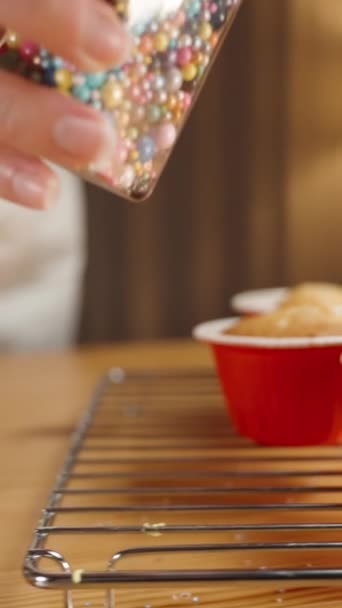 Die Konditorin Bestreut Cupcake Mit Pfirsichfarbenem Zuckerguss Mit Zuckerstreusel Form — Stockvideo