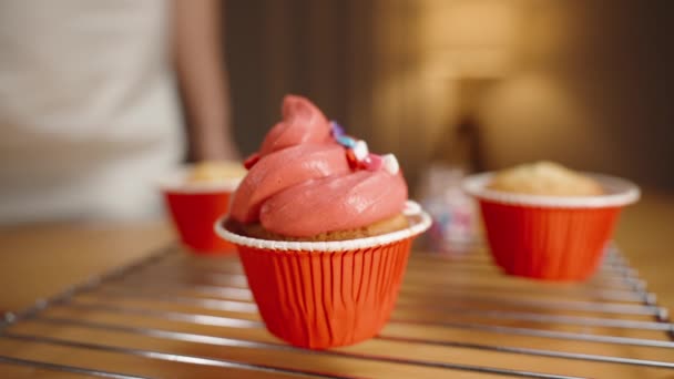 ペストリーシェフは 赤いフロスティングでカップケーキに多色のハートの形で砂糖を吐き出します スローモーション クローズアップ — ストック動画