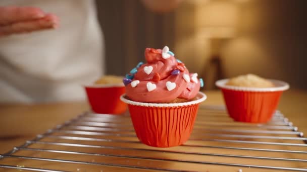 Ζαχαροπλάστης Διακοσμεί Κόκκινα Cupcakes Καρδιές Ζάχαρης Κοντινό Πλάνο — Αρχείο Βίντεο