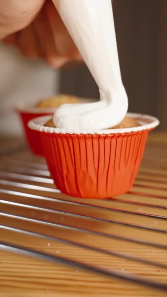 糕点厨师用白色奶油装饰一个纸杯蛋糕 把它从管道袋中挤出来 慢动作 — 图库视频影像