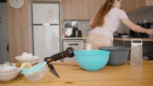 テーブルの上の生地のための成分 白いエプロンの女性はスプーンを拭きます ホームキッチン — ストック動画