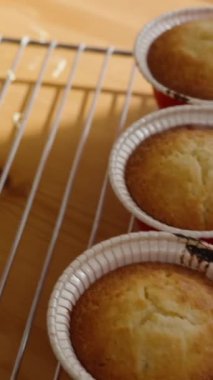 Bir kadın pencereden güneş ışığı altında kek süslemek için sarı krema karıştırıyor..