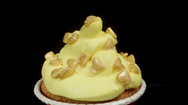 その上に黄色いフロスティングと黄砂糖の心を持つカップケーキ ドリースライダー クローズアップ — ストック動画