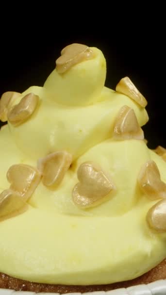 その上に黄色いフロスティングと黄砂糖の心を持つカップケーキ ドリースライダー クローズアップ — ストック動画