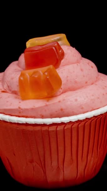 ピンクのフロスティングにマーマレードで作られた Love の銘板付きのカップケーキ 隔離された黒い背景のループ回転 — ストック動画