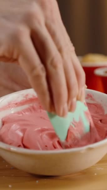 カップケーキにピンクのクリームを混ぜながら テーブルの上にさまざまなスパイクや装飾 — ストック動画