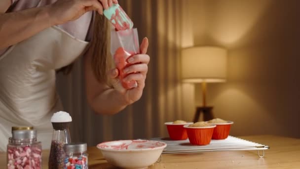 这个女人正在用红色的奶油填充一个糕点袋来装饰蛋糕 — 图库视频影像