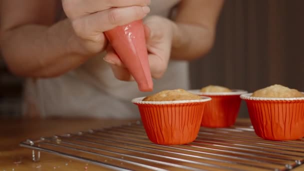 Mujer Está Aplicando Glaseado Rojo Una Bolsa Pastelería Los Cupcakes — Vídeo de stock