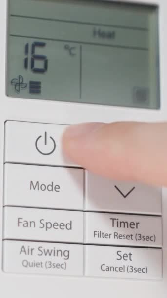 バーティカルビデオ ホワイトウォールのエアコンのリモートコントロール 男性の手はそれをオンにし 最大に温度を増加させます ヒーティングモード — ストック動画