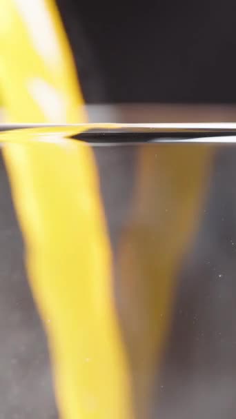 垂直录像 在玻璃杯中倒入橙汁 从玻璃杯中的气泡中喷出蒸汽 动作缓慢 — 图库视频影像