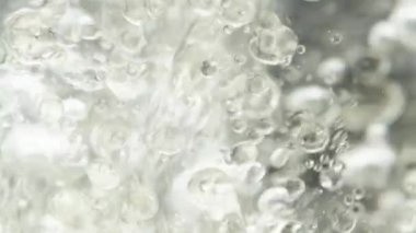 Sudaki binlerce yağ damlası, siyah arka planda hava kabarcıkları. Makro çekim.