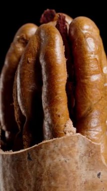 Dikey video. Yarı Kabuklu Ceviz Kara Arkaplan 'da Yavaşça Dönüyor, Macro.