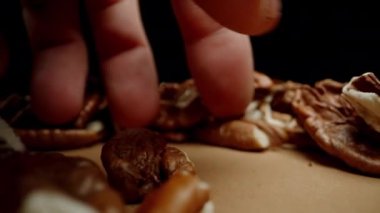 Bir adamın eli masadan ceviz toplar. Dolly kaydırıcı, kapat..