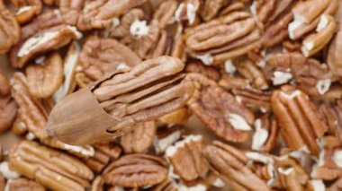 Kaydırıcı atışı. Fındık cevizi soyulmuş fındıkların arka planında dönüyor, üst görünüm.