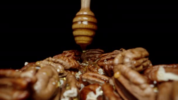 Pekannüsse Mit Honig Aus Einem Kochlöffel Nahaufnahme Auf Schwarzem Hintergrund — Stockvideo