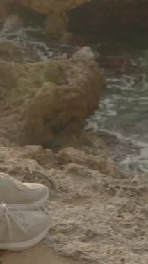 Dikey video. Kadın battaniyenin üzerinde tek başına oturuyor ve erkeği bekliyor, şampanya ve çilek şişesinin yanına iki bardak yerleştiriliyor, dışarı çıkmıyor..