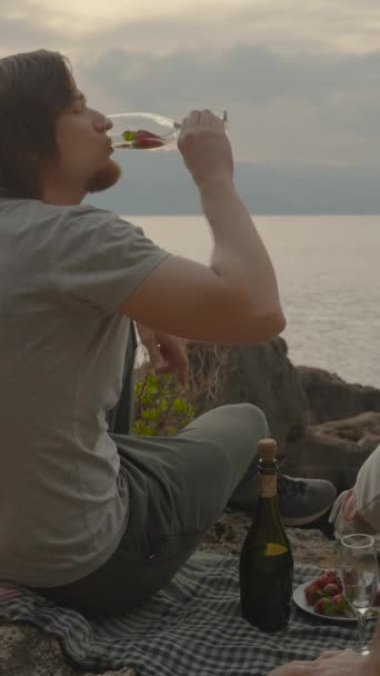 Dikey Video Deniz Tarafından Günbatımında Genç Bir Çift Erkek Şampanya — Stok video