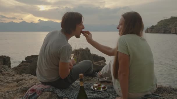 Aşık Deniz Kenarındaki Battaniyeye Oturur Kadın Çileği Besler Şampanyayı Çer — Stok video