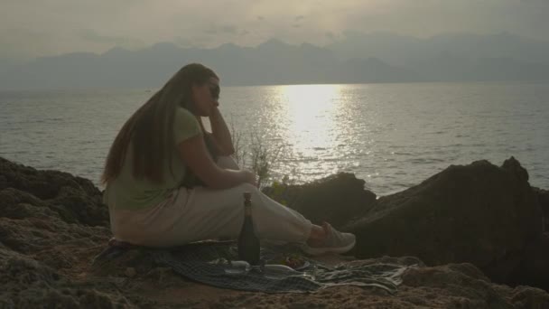 Traurig Sitzt Die Junge Frau Bei Sonnenuntergang Meer Und Wartet — Stockvideo