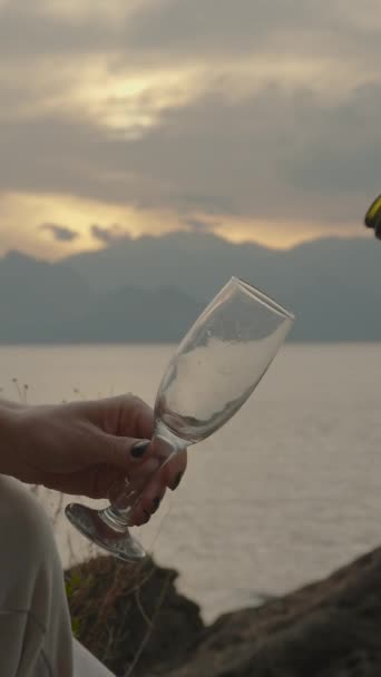 Вертикальное Видео Мужчина Разливает Шампанское Женщины Стекло Свидание Закате Моря — стоковое видео