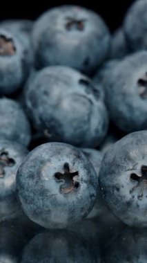 Dikey video. Bir el masadaki yaban mersinini topluyor. Kaydırıcı.