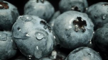 Meyveli yaban mersini masada toplandı ve su damlacıklarıyla kaplandı. Dolly kaydırıcı, makro.