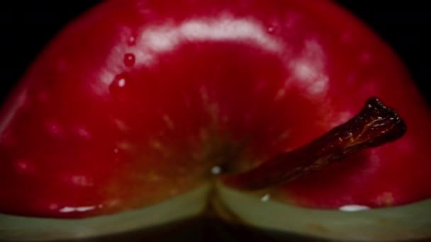 Een Halve Rode Appel Ligt Een Zwarte Tafel Met Waterdruppels — Stockvideo