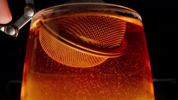 茶叶筛子在玻璃杯中旋转 微粒沉淀在杯底 — 图库视频影像
