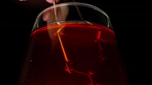 金属のふるいが付いているガラスで黒茶をかき混ぜる クローズアップ — ストック動画