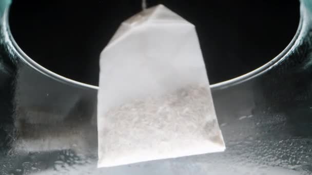 Ένα Φακελάκι Τσαγιού Μιας Χρήσης Βυθίζεται Στο Ποτήρι Βραστό Νερό — Αρχείο Βίντεο
