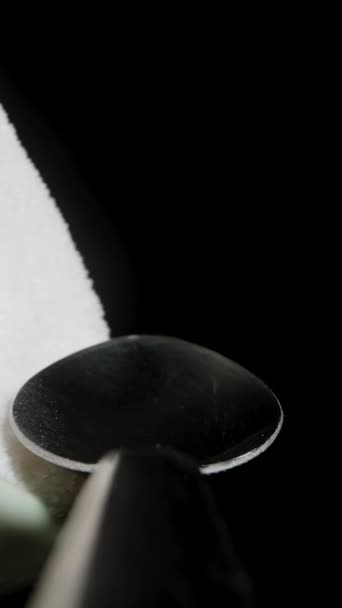 バーティカルビデオ スプーン ファーストパーソンマクロビューのグラスに砂糖をスプリンクル ブラックバックグラウンド — ストック動画