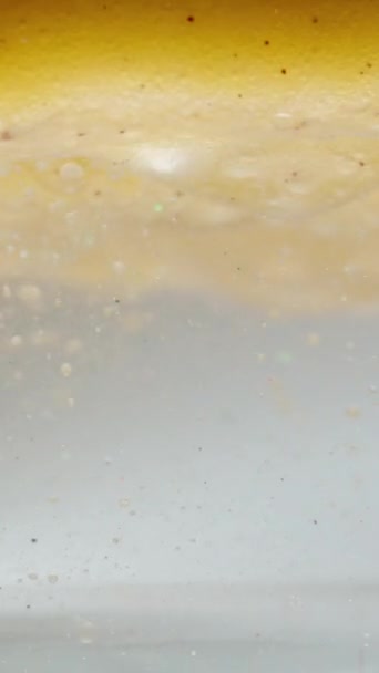 垂直录像 两个密度不同的液体不要混合在一起 水中的油和金颗粒 — 图库视频影像