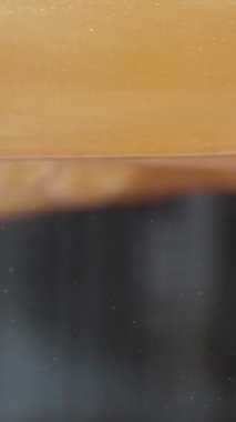 Dikey video. Suda Altın Sıvı, Farklı Yoğunluklar Birarada Karışmaz. Makro Kimyasal Süreç.