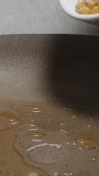 Вертикальное Видео Кукурузные Зерна Попкорна Выливаются Сковороду Маслом Замедленным Крупным — стоковое видео
