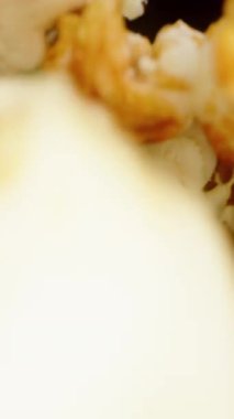 Dikey video. Makro kaydırıcı renkli patlamış mısırın içinden geçiyor, ve bir el onu topluyor, yavaş çekim..