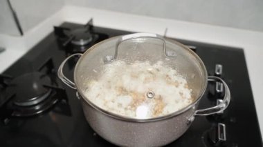 Gaz ocağında, patlamış mısırlı bir tencere, ağır çekimde dairesel görüş..