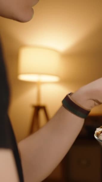 비디오 여자는 텔레비전 앞에서 팝콘을 먹는다 램프에서 희미하고 따뜻한 — 비디오