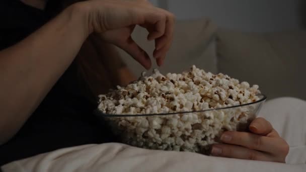 Una Giovane Donna Mangia Popcorn Mentre Seduta Sul Divano Davanti — Video Stock