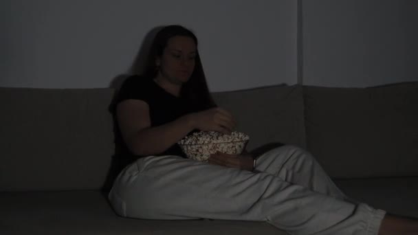 Una Donna Siede Sul Divano Mangiando Popcorn Con Luce Del — Video Stock