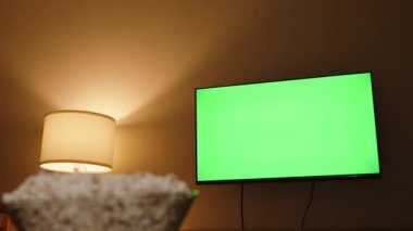 Yeşil TV ekranındaki kameranın seçici odağı ve ön plandaki el patlamış mısırı aldı..