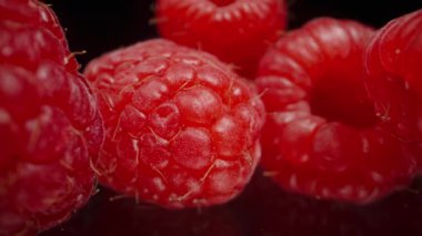 Ahududu siyah aynalı bir masaya saçılmış, yavaş doli. Makro çekim.