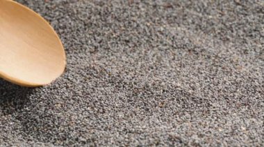 Haşhaş tohumları bir tahta kaşıkla toplanır ve en üste yerleştirilir..