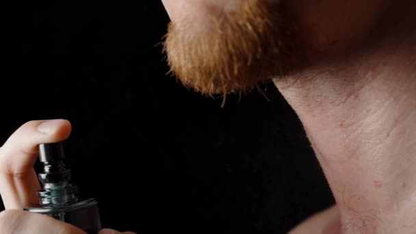 Een Man Met Een Baard Spuit Parfum Uit Een Zwarte — Stockvideo