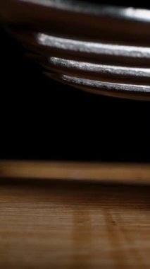 Dikey video. Haşlanmış tavuk yumurtaları ezilir ve ahşap bir masada çatalla ezilir. Dolly kaydırıcı, yakın plan..